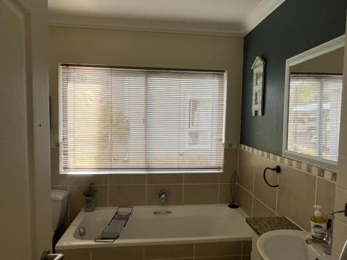 a bathroom with a bath tub and a sink at Marina View in Jeffreys Bay