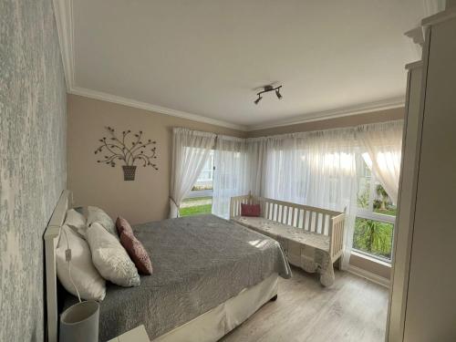 a bedroom with a bed and a window with a crib at Marina View in Jeffreys Bay