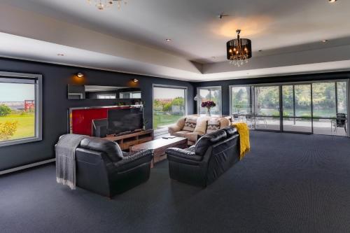 a living room with two couches and a tv at Riverstone House in Camerons