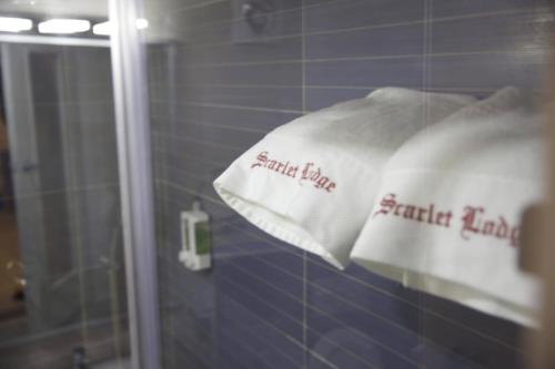twee witte handdoeken op een rek in een badkamer bij Scarlet Lodge in Lagos