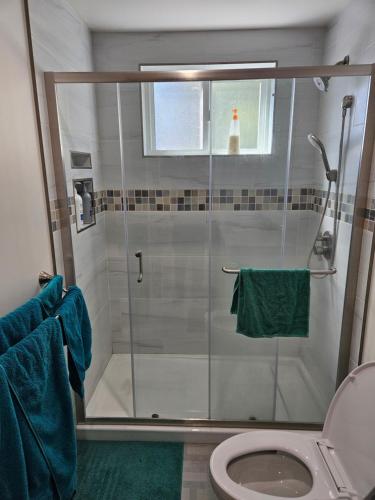 a bathroom with a shower with a toilet and blue towels at Sunset location 2Bed/1Bath Apt close to Golden Gate Park in San Francisco