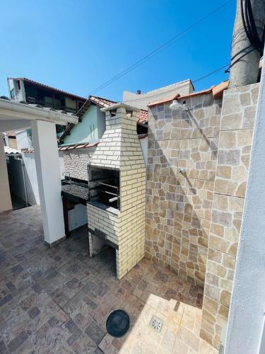 a brick wall with a grill on a patio at Morada do Mar Arraial do Cabo in Arraial do Cabo