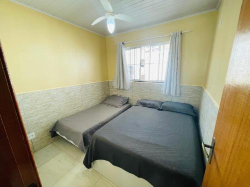 a bedroom with two beds and a window at Morada do Mar Arraial do Cabo in Arraial do Cabo
