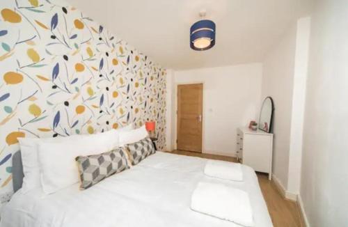sypialnia z białym łóżkiem i kwiatową ścianą w obiekcie Spacious one bedroom apartment w mieście Reading