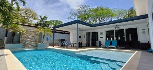uma piscina em frente a uma casa em Playa Potrero - modern 3 BR home centrally located - Casa Coastal Serenity em Guanacaste