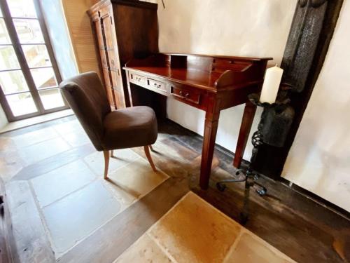 an old wooden desk and chair in a room at Ferienhaus Namibia-Lodge im Rittergut Leppersdorf in Leppersdorf