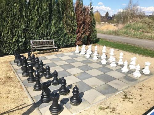 a chess board on a sidewalk with a bench at Ferienhaus Namibia-Lodge im Rittergut Leppersdorf in Leppersdorf