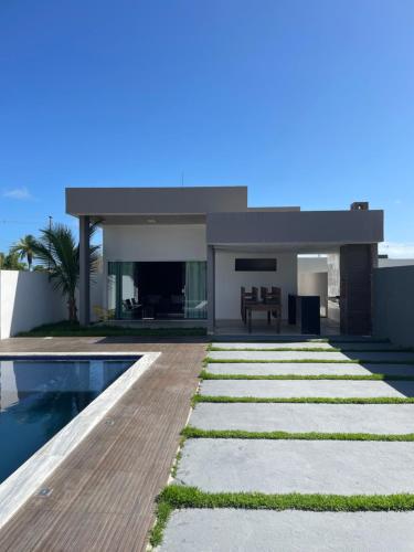 a modern house with a swimming pool and a yard at Casa condomínio fechado Paripueira in Paripueira