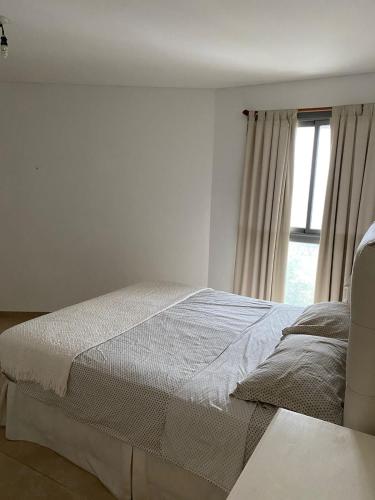 Habitación blanca con cama y ventana en Sonoma Ribera- Gral Paz CBA en Córdoba