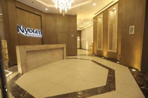 a lobby of a building with a sign on the wall at Duplex-Nyoum New Cairo in Cairo