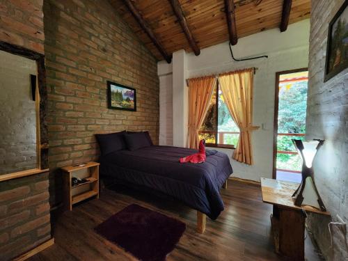 a bedroom with a bed with red shoes on it at Hotel Pueblo del Mundo in Baños