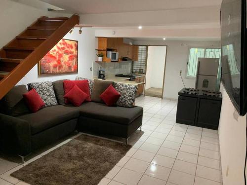 ein Wohnzimmer mit einem Sofa und einer Küche in der Unterkunft Casa ideal con cochera, seguridad y céntrica in Mazatlán