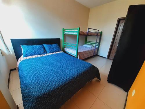 a bedroom with a bed with a blue comforter at Ayenda Mountain Hostels Manizales in Manizales