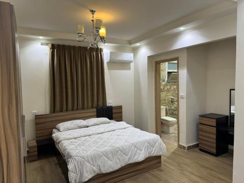 a bedroom with a large bed and a bathroom at 4شارع نبلس المهندسين in Cairo