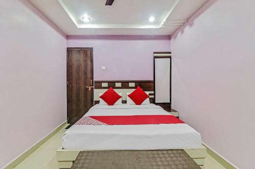 a bedroom with a large bed with red pillows at Hotel O Royal in Rāj Nāndgaon