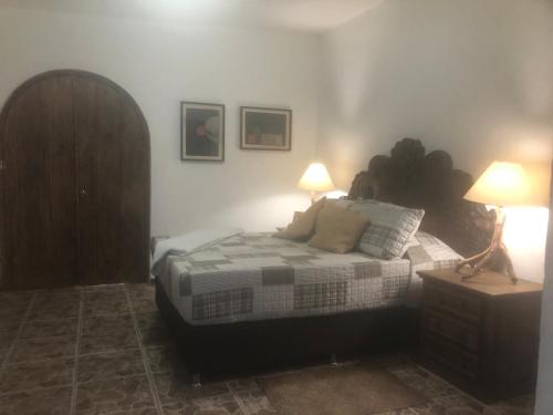 ein Schlafzimmer mit einem Bett und zwei Lampen auf einem Tisch in der Unterkunft San Gabriel’s House at Chapalita(Colonia) in Guadalajara