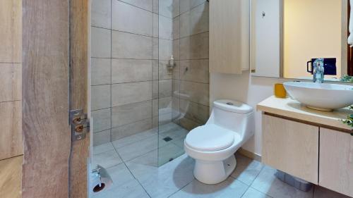 uma casa de banho com um WC, um lavatório e um chuveiro em Your Home in the Heart of Bogotá em Bogotá