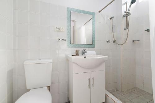 ein Badezimmer mit einem WC, einem Waschbecken und einem Spiegel in der Unterkunft Perfectly Located Studio by Rushcutters Bay Park in Sydney