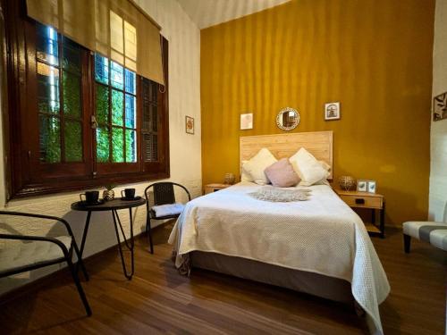 1 dormitorio con cama y pared amarilla en Terminal expres, en Montevideo