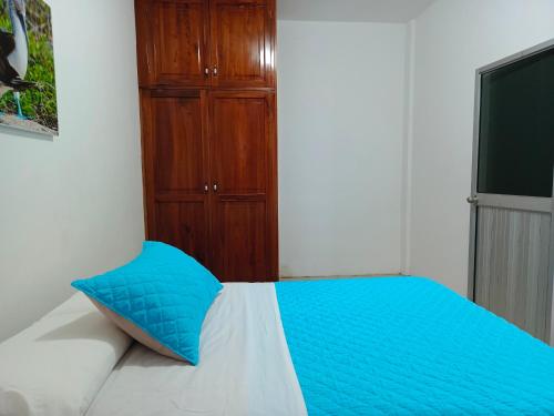 een blauw kussen op een bed in een slaapkamer bij Teresita's House Suites 2 con cocina privada in Puerto Baquerizo Moreno
