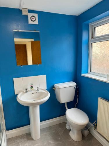 Baño azul con aseo y lavamanos en Transformative housing birrell road en Nottingham
