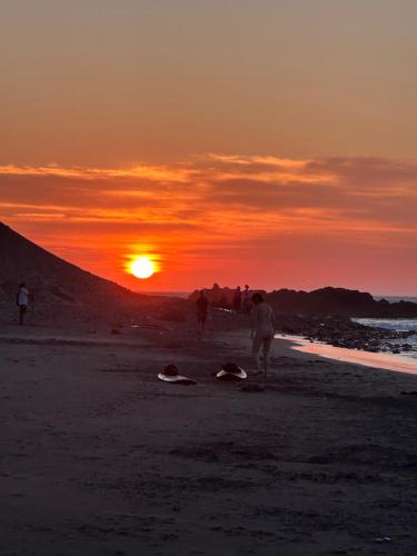 a group of people on the beach at sunset at La isla surf Camp de punta hermosa in Punta Hermosa