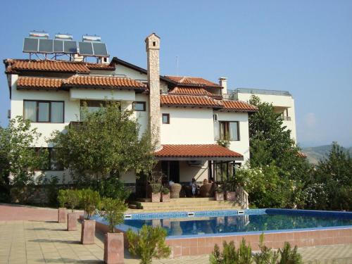 a house with a swimming pool in front of it at Hotel Villa Ofir in Sandanski