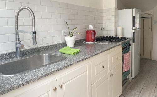 um balcão de cozinha com um lavatório e um fogão em Totem em Mar del Plata