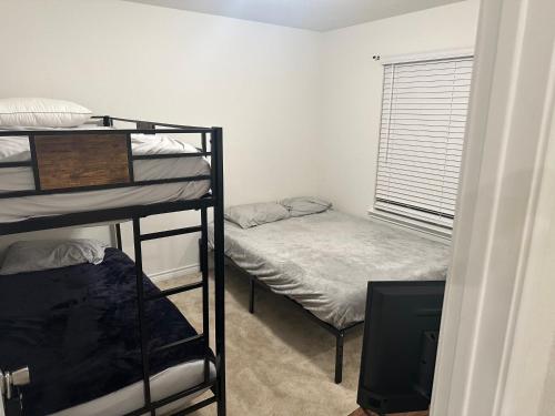 聖安東尼奧的住宿－Spacious Room for Rent: Conveniently Located near Highway 1604!，客房设有两张双层床和电视。