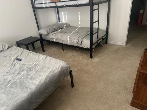 聖安東尼奧的住宿－Spacious Room for Rent: Conveniently Located near Highway 1604!，一间卧室设有两张双层床和一张桌子