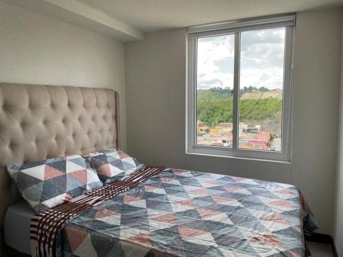 een slaapkamer met een bed en een groot raam bij Apartamento cómodo y exclusivo in Villa Nueva