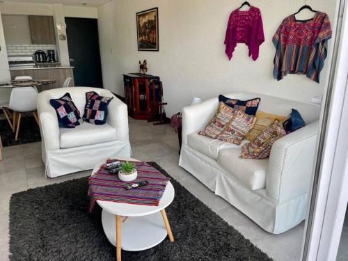 a living room with two white couches and a table at Apartamento cómodo y exclusivo in Villa Nueva
