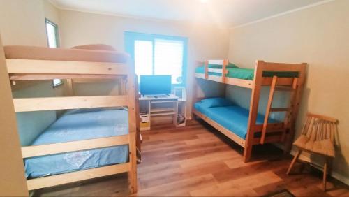 a room with three bunk beds and a desk at Alojamiento familiar Ñuñoa con estacionamiento a pasos del Estadio Nacional e ISP in Santiago