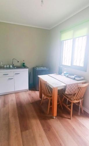a kitchen with a table and chairs in a room at Alojamiento familiar Ñuñoa con estacionamiento a pasos del Estadio Nacional e ISP in Santiago