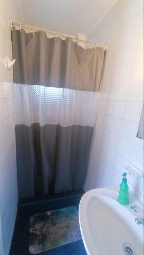 a bathroom with a shower curtain and a sink at Alojamiento familiar Ñuñoa con estacionamiento a pasos del Estadio Nacional e ISP in Santiago