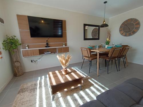 een woonkamer met een tafel en een televisie bij Moderna y Cómoda Casa - Vista Al Volcán in Villarrica