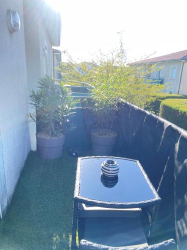 a small table with a stack of plates on a patio at Élégant T2 Blagnac - parking -aéroport-Airbus- Meett in Blagnac