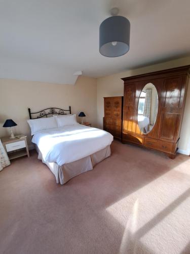 1 dormitorio con 1 cama grande y espejo grande en House in the countryside, en Cork