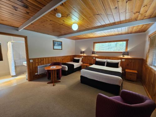 a bedroom with two beds and a table and chairs at Tall Timbers Tasmania in Smithton