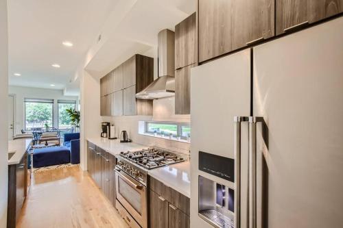 a kitchen with stainless steel appliances and wooden cabinets at Upscale Townhome w/ Stunning Rooftop Views in Denver