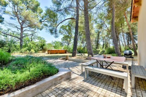 um pátio com uma mesa de piquenique e comodidades para churrascos em Pinède house furnished em Aix-en-Provence