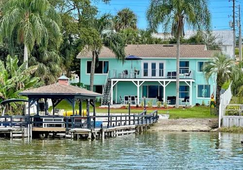 a blue house with a dock in the water at Lakefront Duplex With Pontoon Boat 3 Bed House in Mount Dora