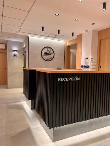 a reception desk in a building with a reeder sign at Pensión La Orozca Benidorm in Benidorm