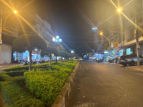a city street at night with street lights and motorcycles at Friendly Homestay in Kon Tum