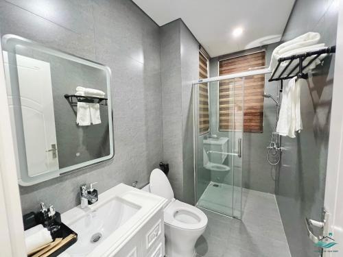 y baño con ducha, aseo y lavamanos. en Royal Beach Villa Sonasea Vân Đồn Quảng Ninh 