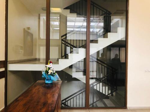 a staircase with a vase of flowers on a wooden table at Hannatel Rooms Liberté in Douala
