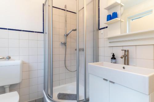 a bathroom with a shower and a sink and a toilet at Haus Deichglück, Whg Timmy in Vollerwiek