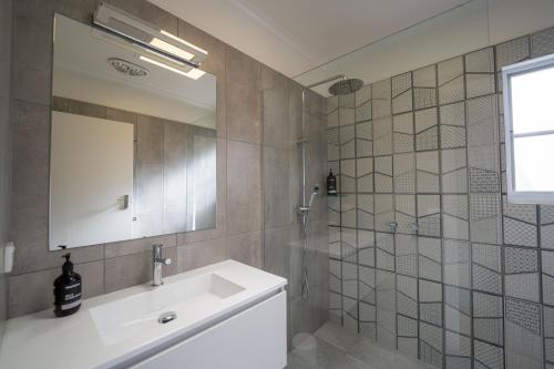 ein Bad mit einem Waschbecken und einem Spiegel in der Unterkunft The Royal Cottage in Mildura