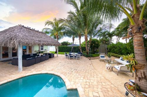 un patio trasero con piscina y palmeras en Jupiter Breeze Haven, en Jupiter