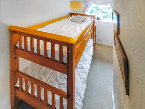 a wooden bunk bed in a room with a window at The Popples in Ivybridge